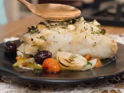 Lombo de bacalhau colocado sobre uma cama colorida de pimentões, aprenda a fazer essa bacalhoada